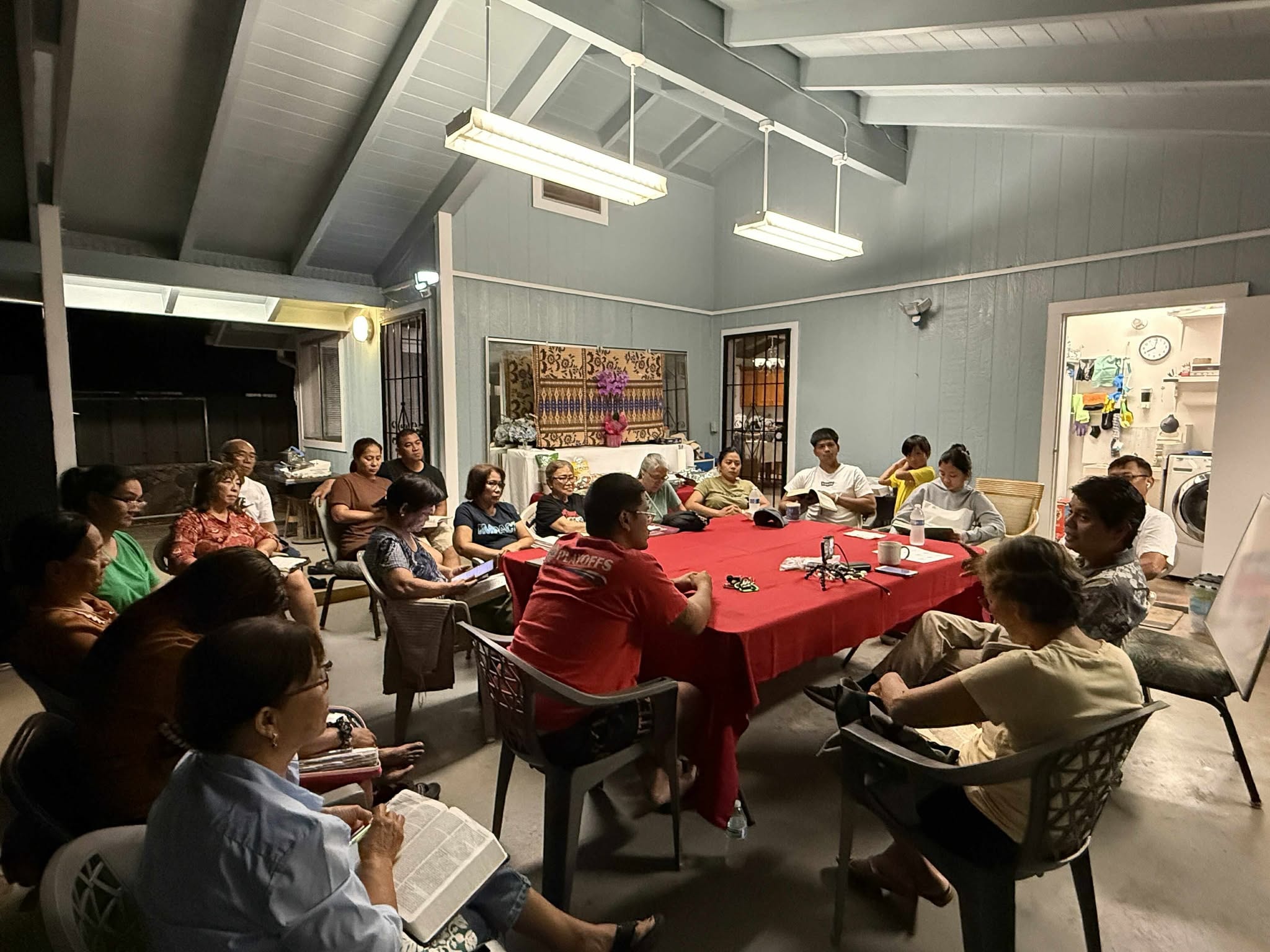 Large group studying the Bible together in a home setting