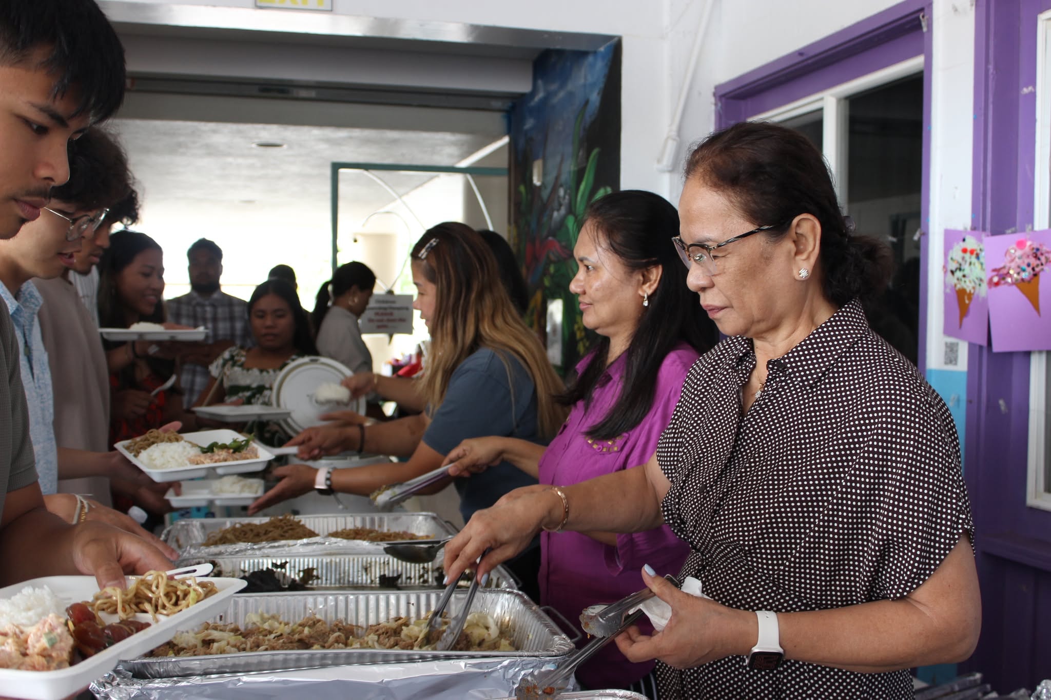 Women smiling together at the fellowship table under Psalm 139:14 banner