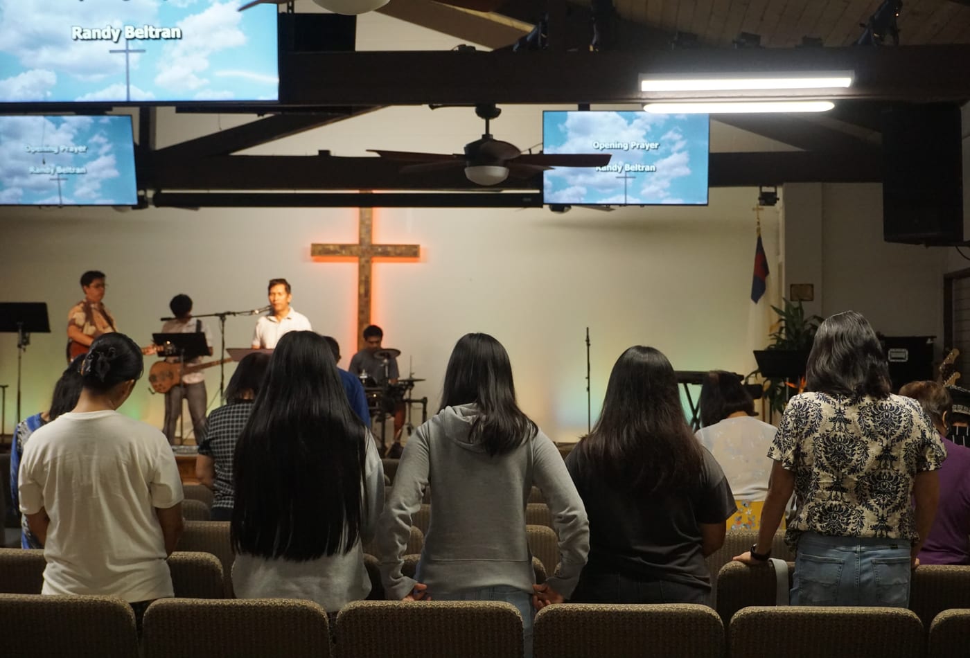 Congregation standing in worship with band on stage