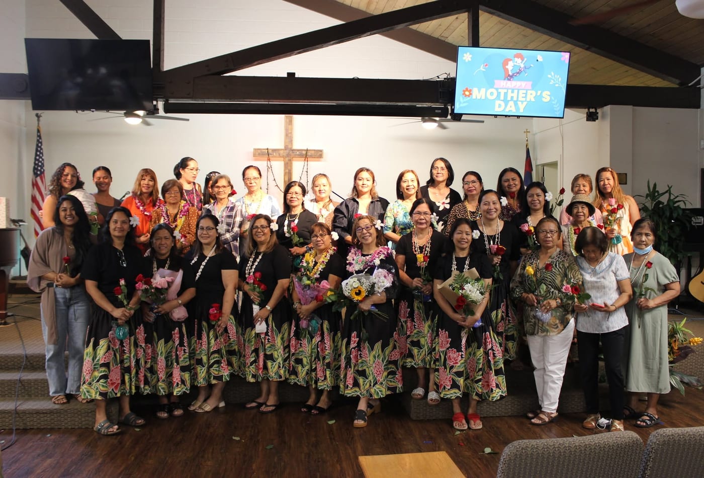 Women celebrating Mother's Day together in the sanctuary holding flowers
